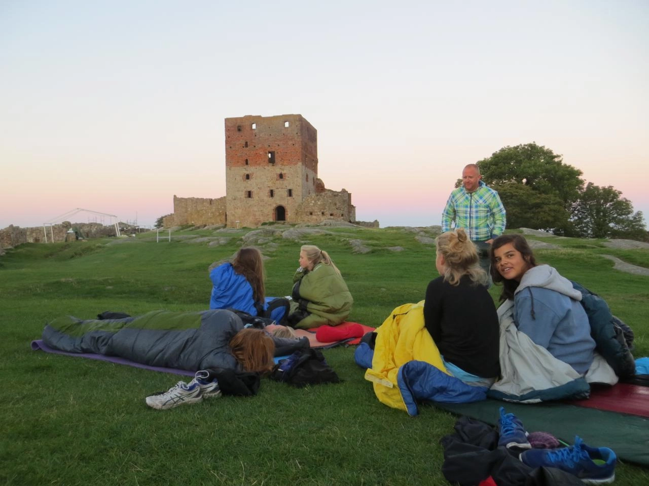 Børn på græsset foran ruin